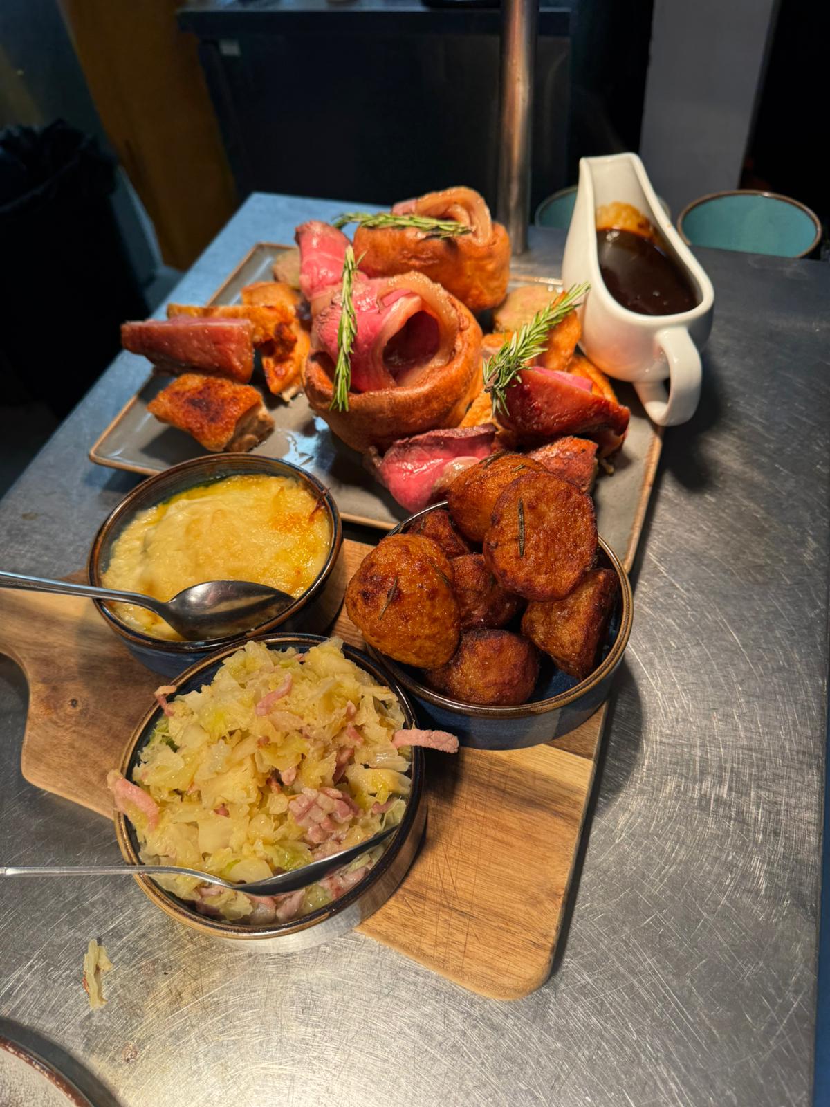 Sunday roast trimmings — cauliflower cheese, roast potatoes and cabbage with bacon