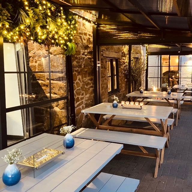 Covered terrace tables lit by warm evening lights